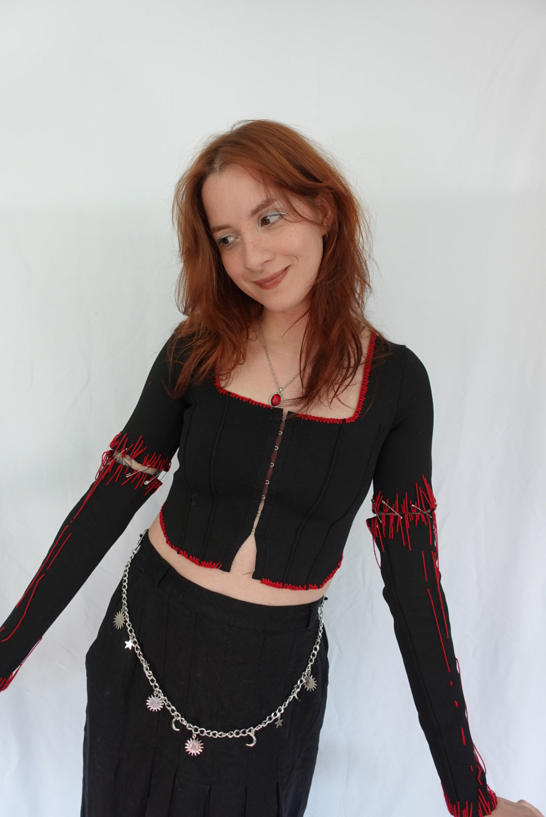 Person wearing a black outfit with red accents on a white background